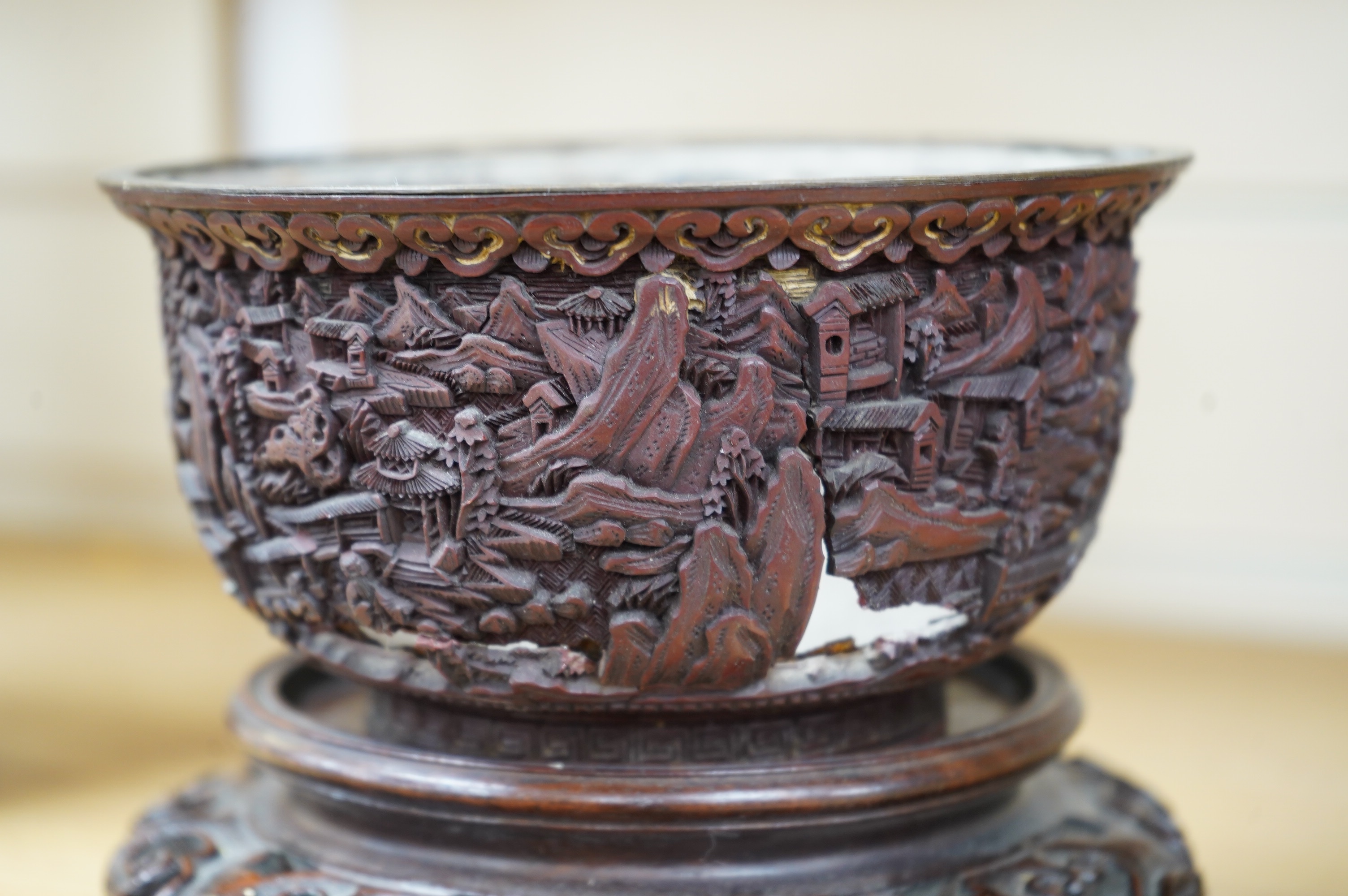 An 18th/19th century Chinese cinnabar lacquer bowl, on carved hongmu stand and a Chinese pierced brass disc. Condition - poor